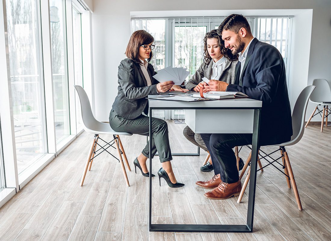 About Our Agency - Female Agent Sits With a Couple in an Office